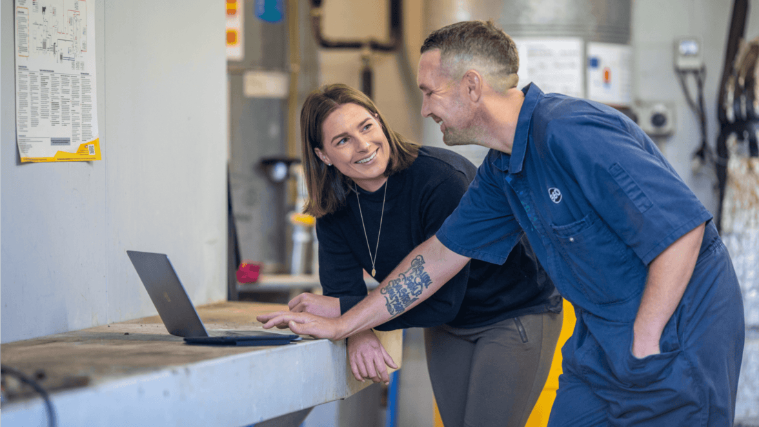 A tradesperson and a colleague laugh at how easy it is to invoice for the job they’ve just finished.